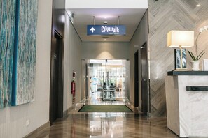 Un vestíbulo de hotel con un letrero de CityWalk, una recepción y un extintor.