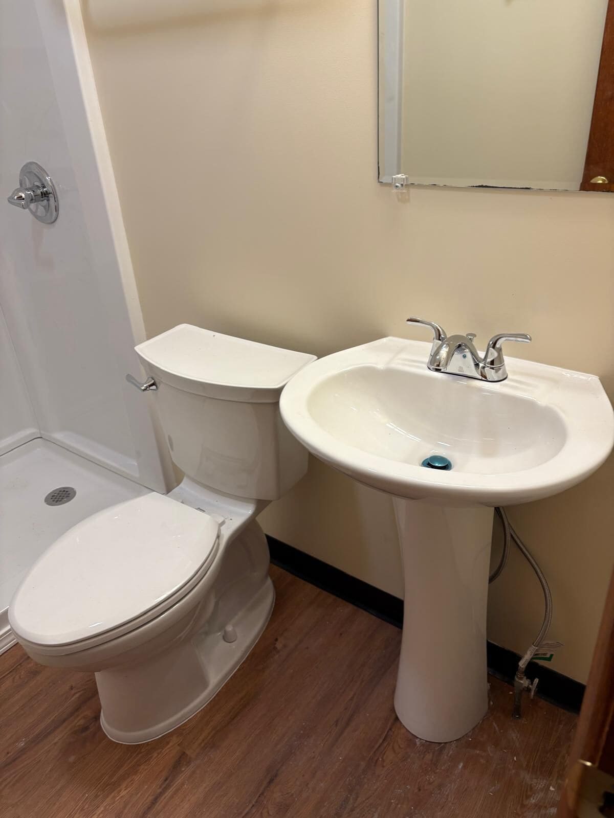 Un baño con inodoro y lavamanos sobrepedal.