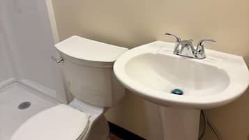 Un baño con inodoro y lavamanos sobrepedal.