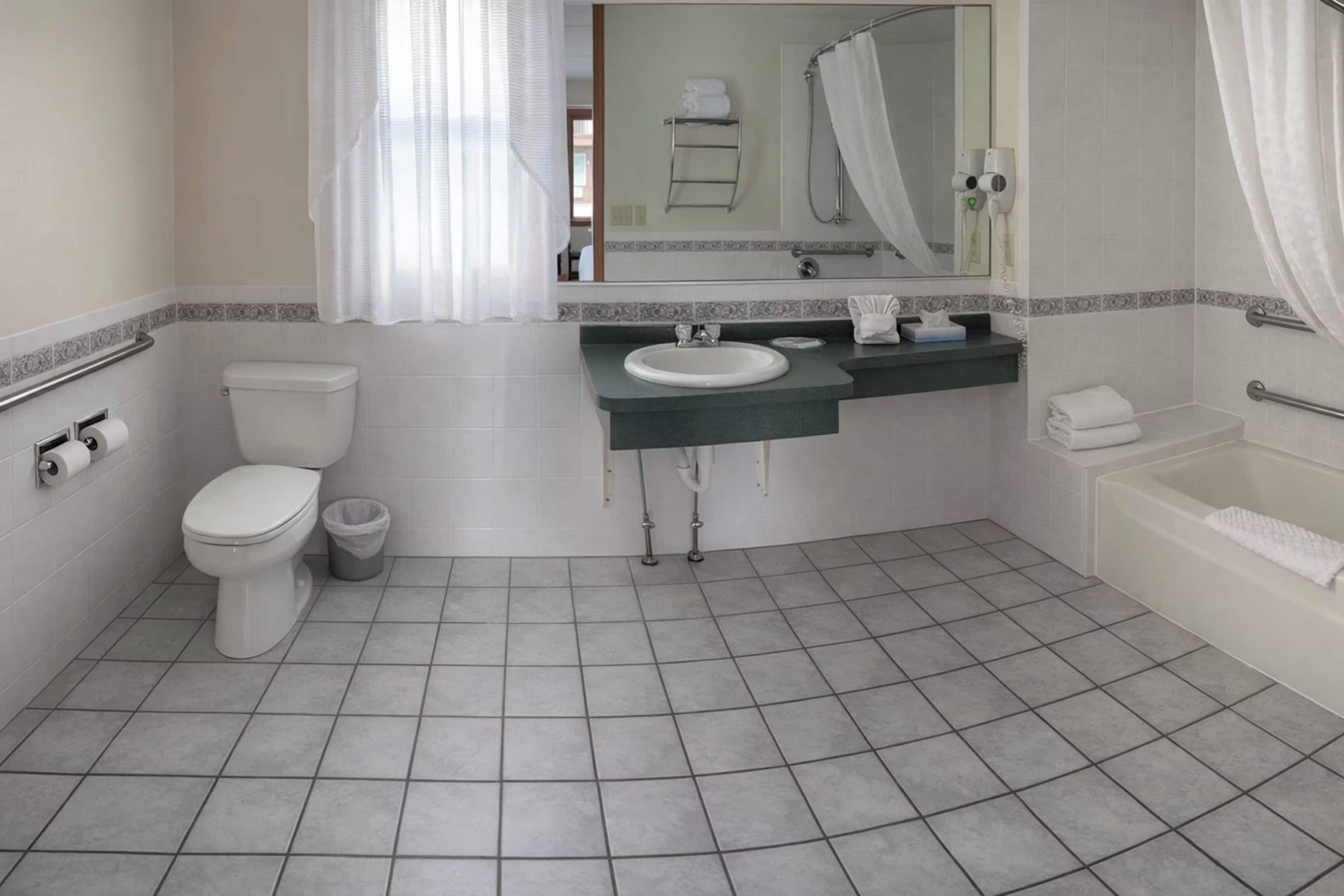 Casa de banho com sanita, lavatório e banheira.