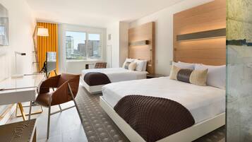 A modern hotel room with two beds, a desk, and a chair.