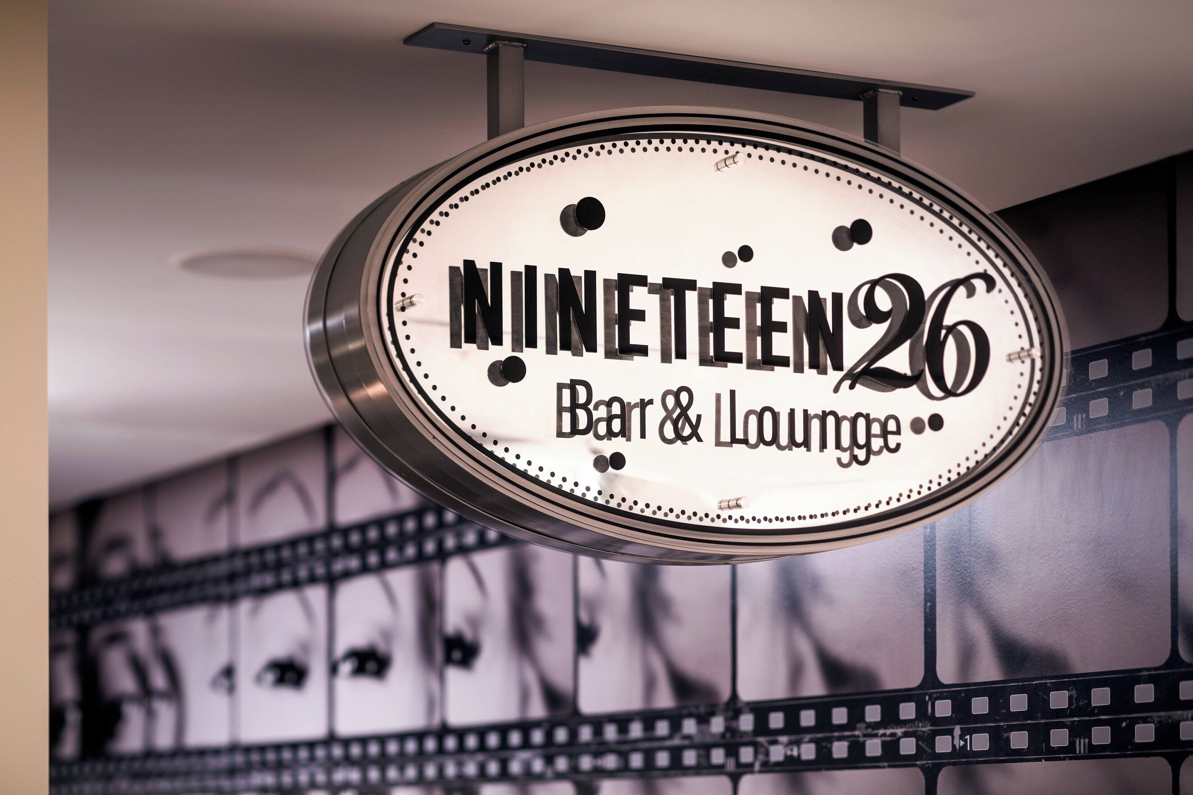 A sign for 'Nineteen26 Bar & Lounge' with a classic design and a film strip background.