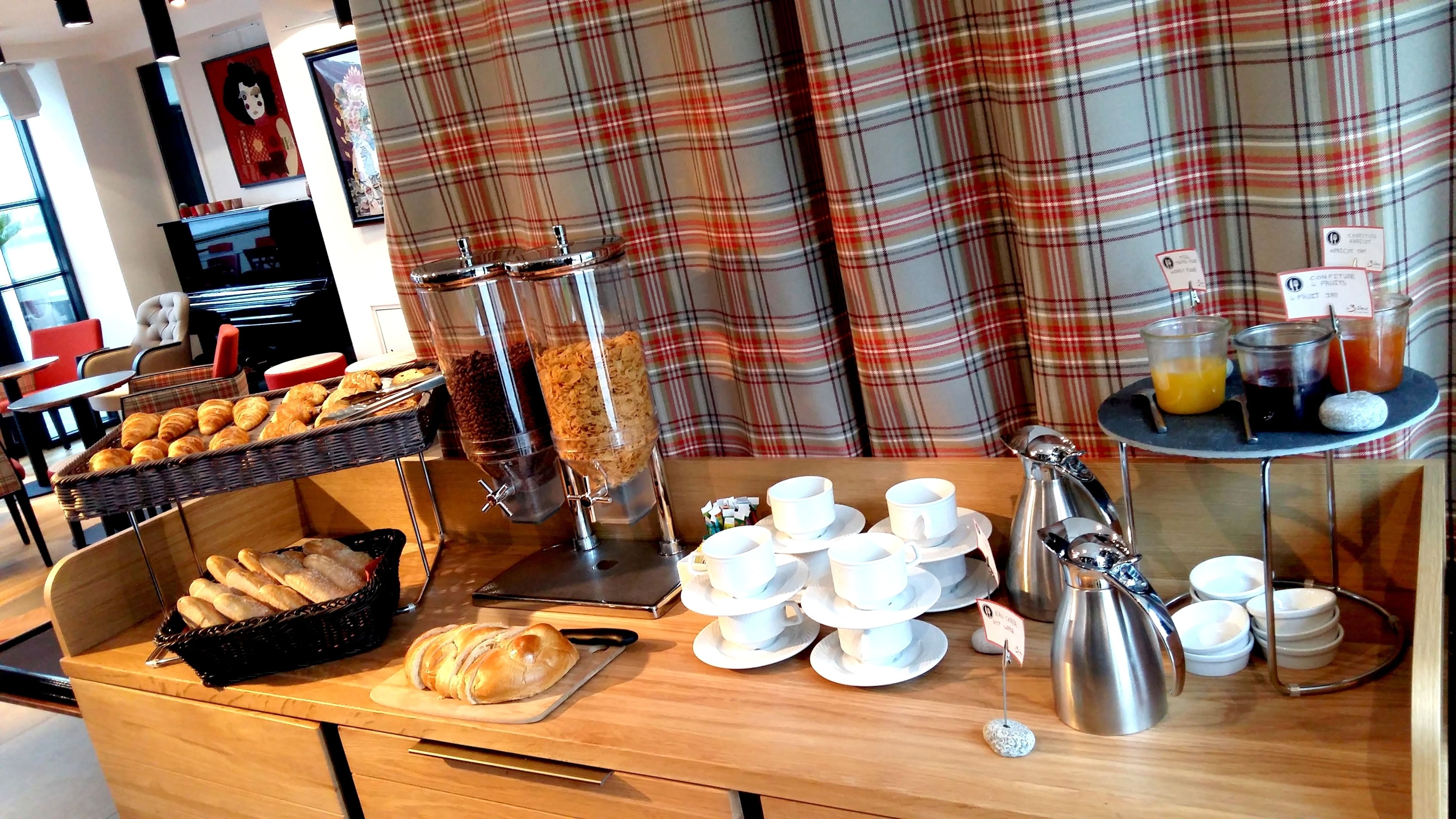 A breakfast buffet with croissants, coffee, and juice.