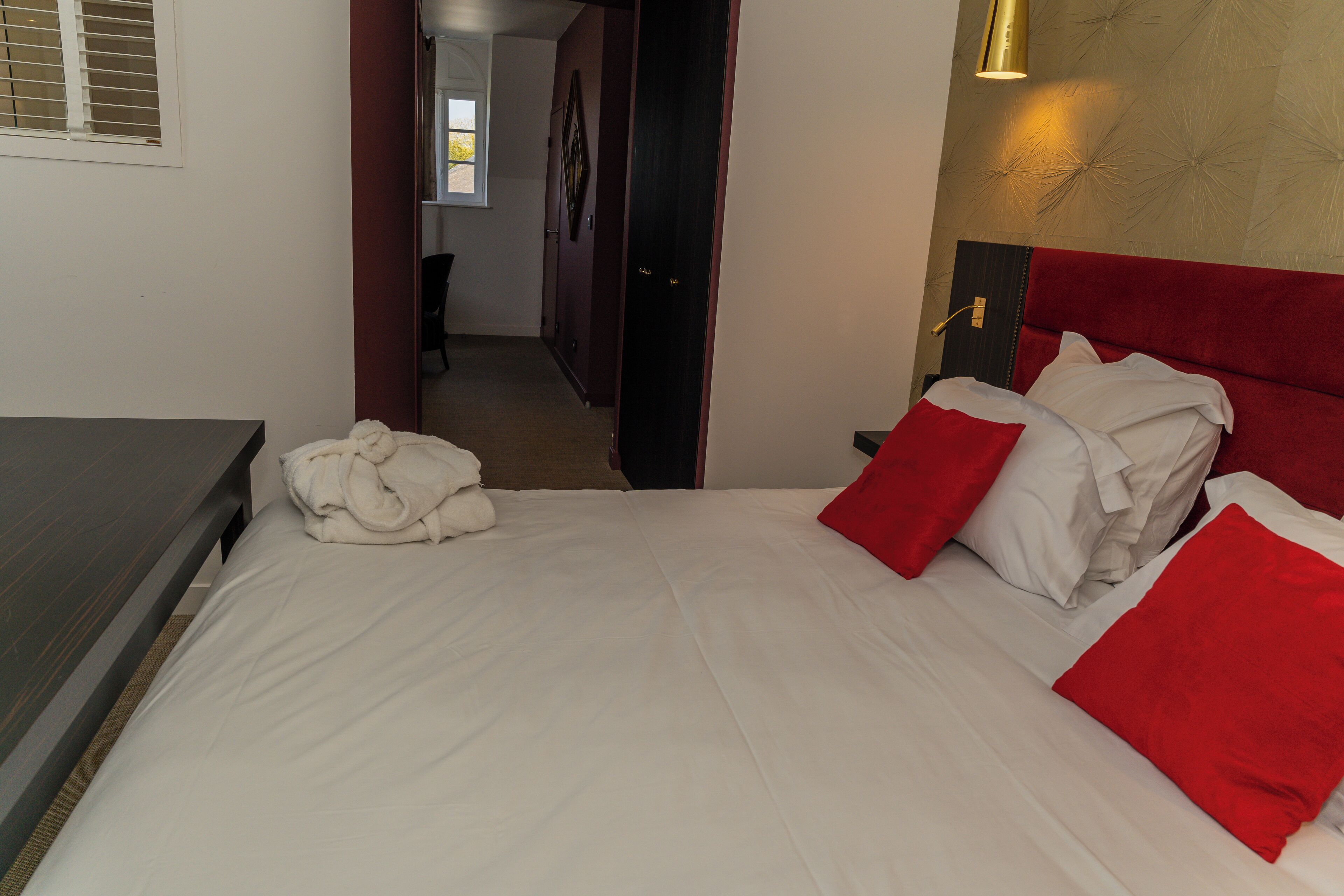 Une chambre d’hôtel avec un lit, une table de chevet et une fenêtre.