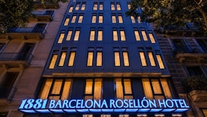 The exterior of the 1881 Barcelona Rosellón Hotel with illuminated signage and multiple windows. - 1881 Barcelona Rosellón Hotel (Barcelona)