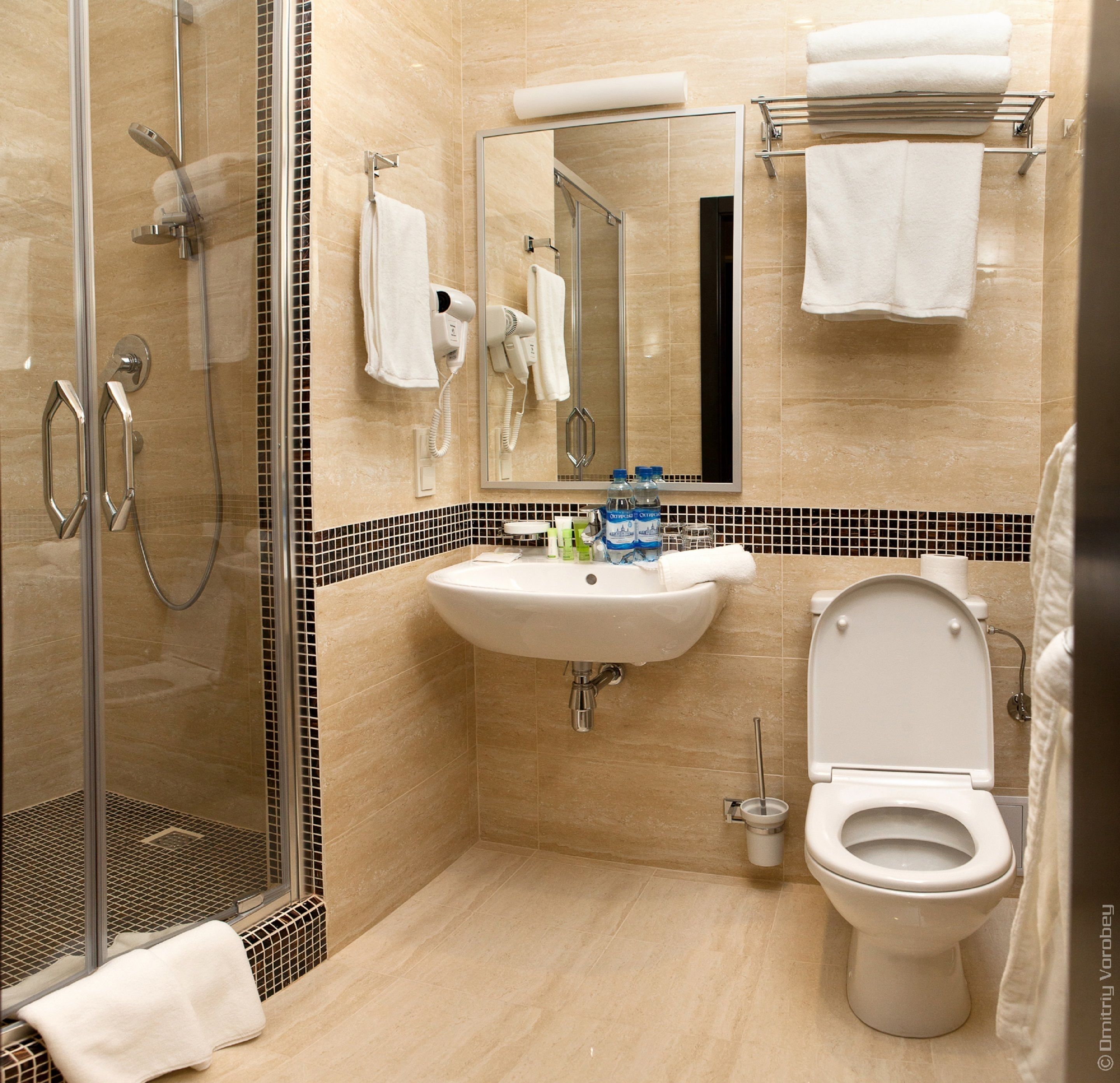 A modern bathroom with a glass-enclosed shower, a sink with a mirror above it, and a toilet.