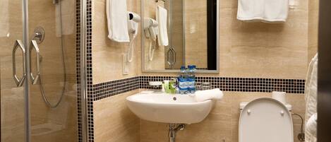 A modern bathroom with a glass-enclosed shower, a sink with a mirror above it, and a toilet.