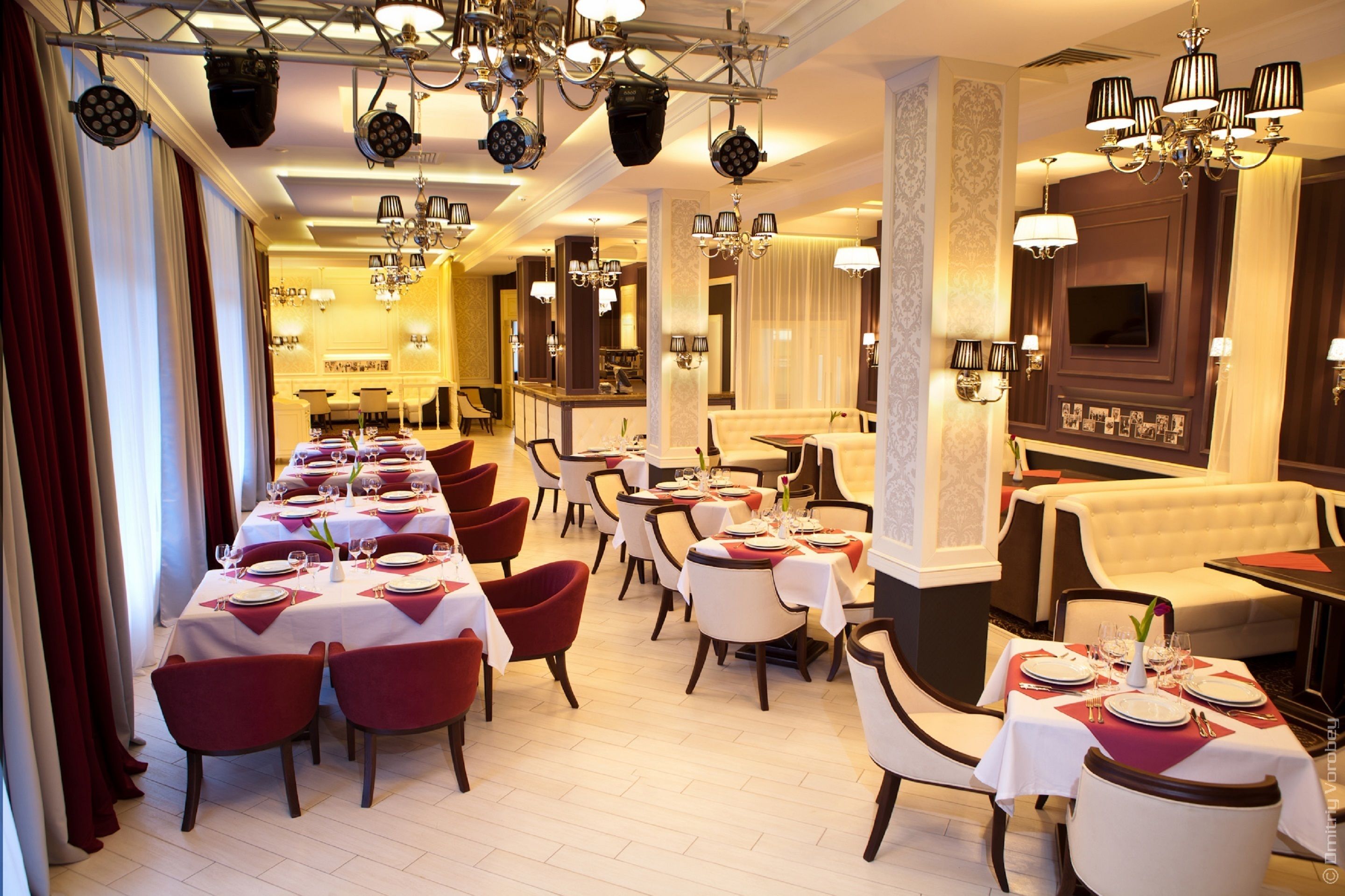 A restaurant with multiple dining tables, chairs, and a bar area.