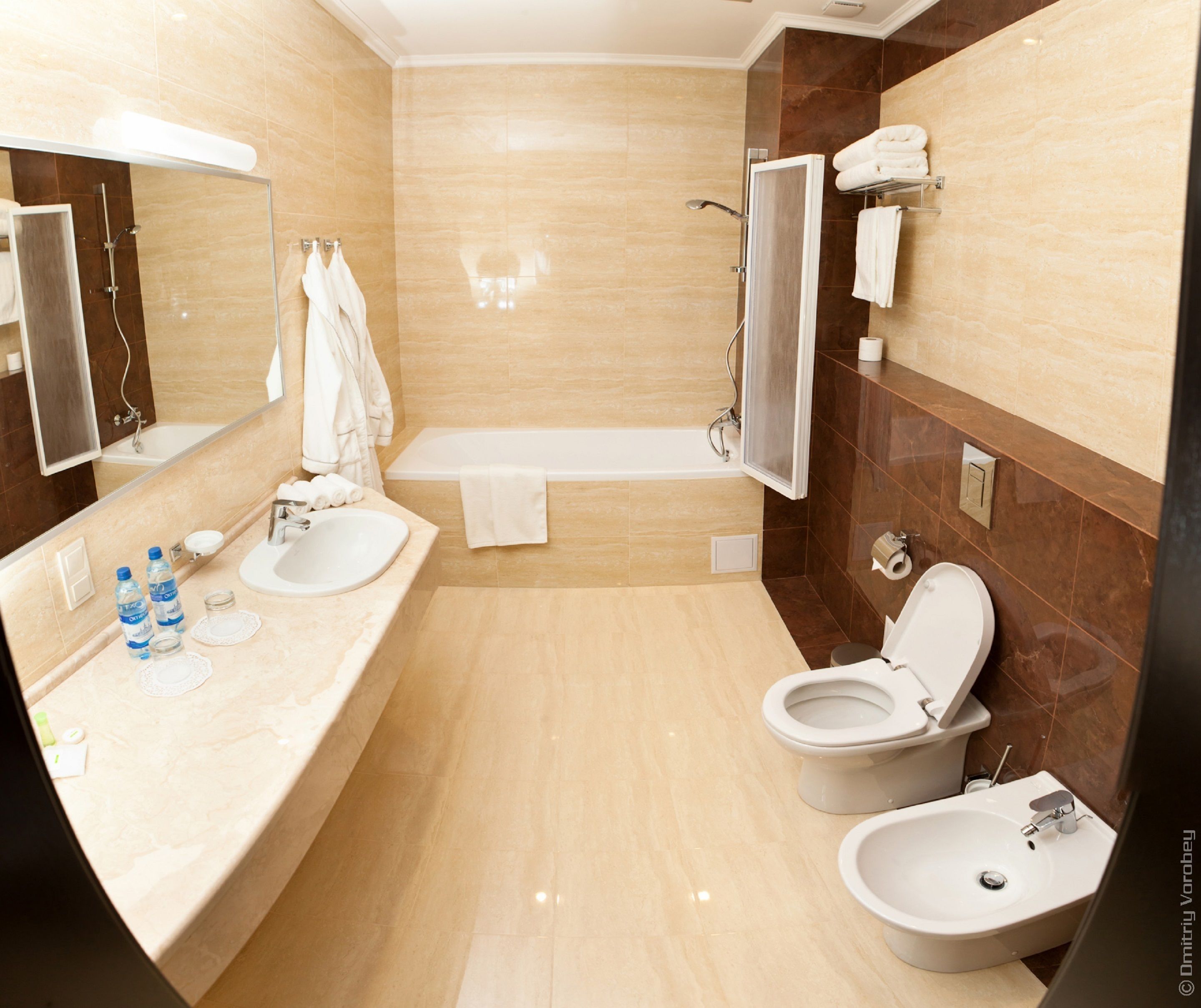 Un baño moderno con bañera, dos lavamanos, inodoro y bidé.