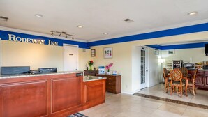 A reception area with a wooden counter, a Samsung TV, and a sign that reads "RODEWAY INN". - Rodeway Inn Bushnell (Bushnell)