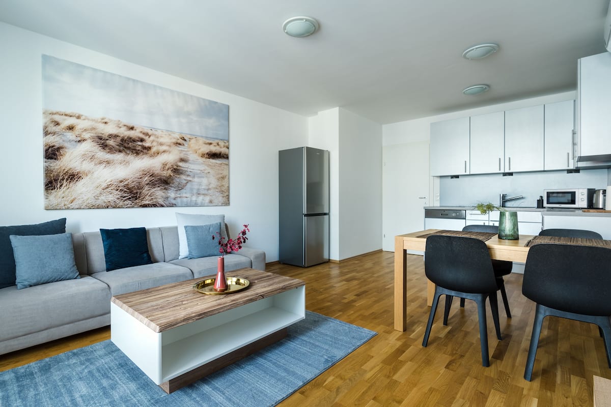 A modern living room with a sofa, coffee table, and artwork.