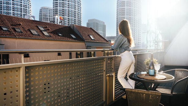 A balcony with a table and chairs, overlooking a cityscape with tall buildings. - Business & Family Ambiente Apartments (Bratislava)