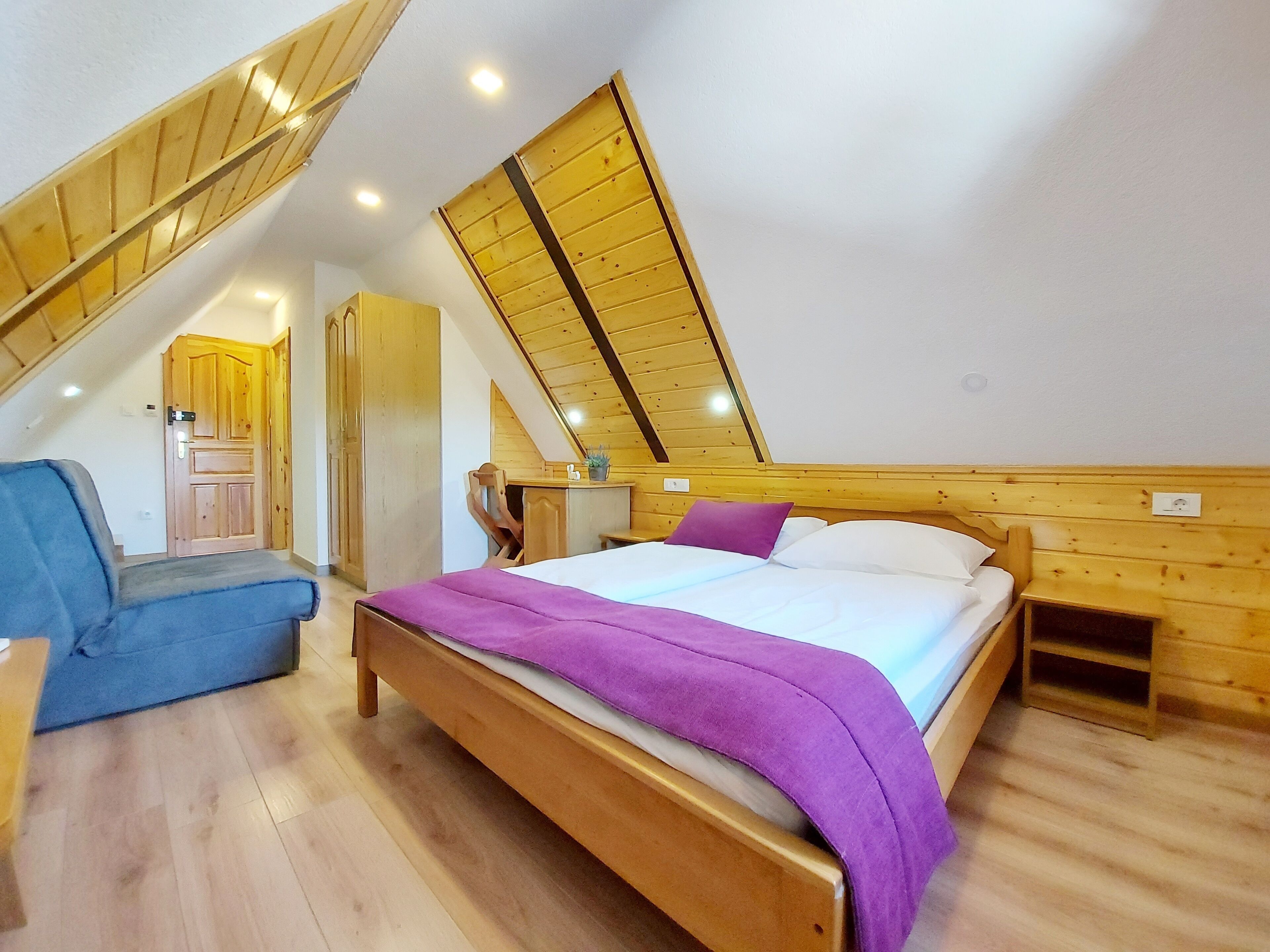 Una camera da letto con un letto in legno, una scrivania e una sedia.