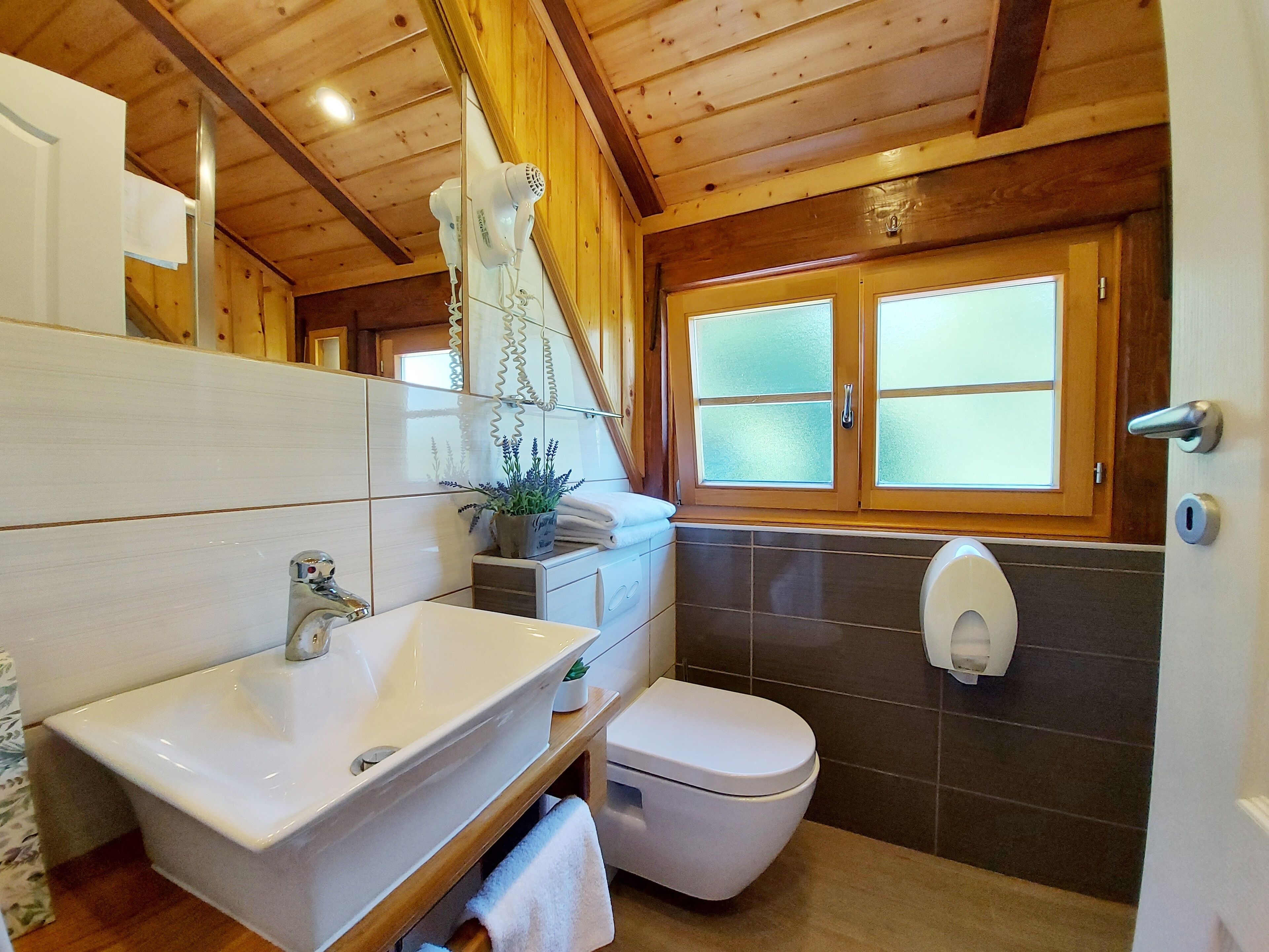 Un baño con un lavamanos blanco, un inodoro y un espejo.