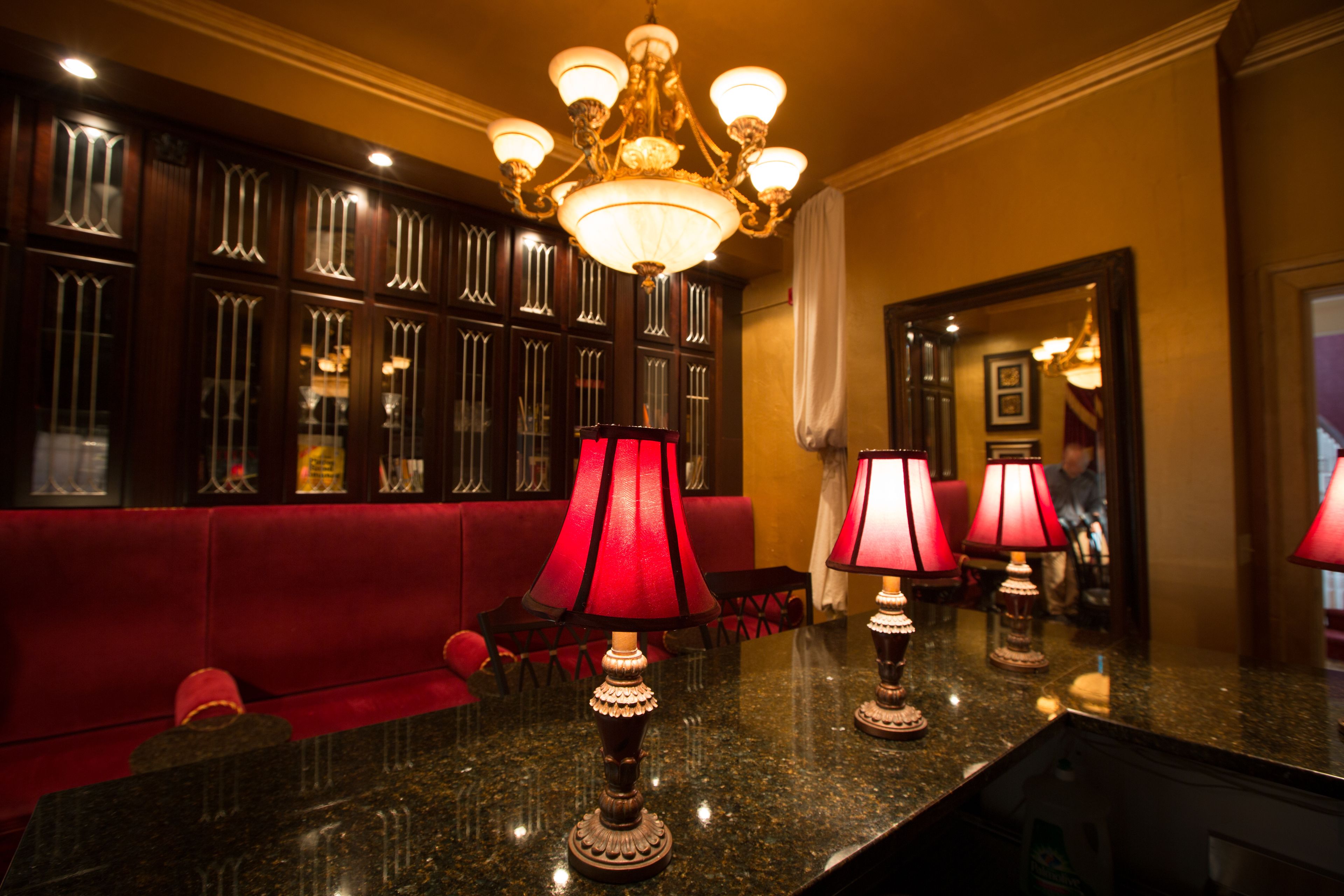 Eine Lobby mit einem roten Sofa, einem Chandelier und mehreren Tischlampen.