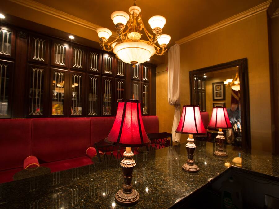 Eine Lobby mit einem roten Sofa, einem Chandelier und mehreren Tischlampen.