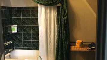 A bathroom with a bathtub, a toilet, and a shower curtain.