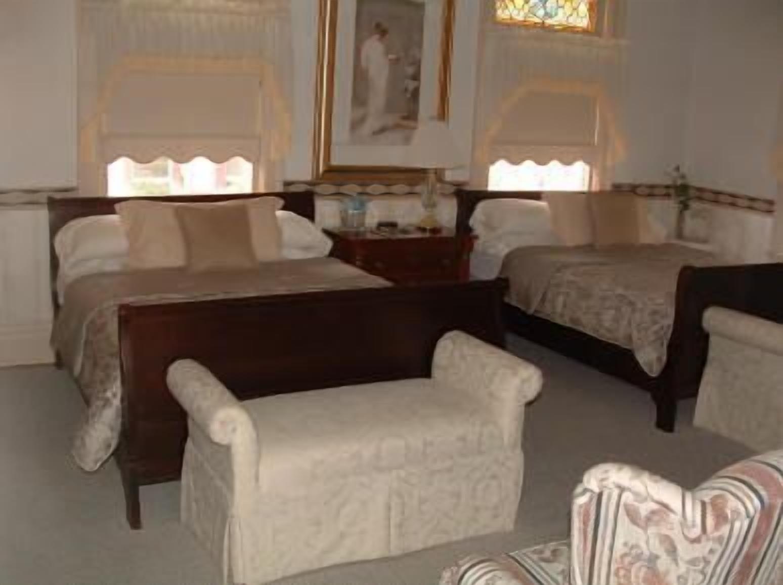 Une chambre d’hôtel avec deux lits, une chaise et une petite table.