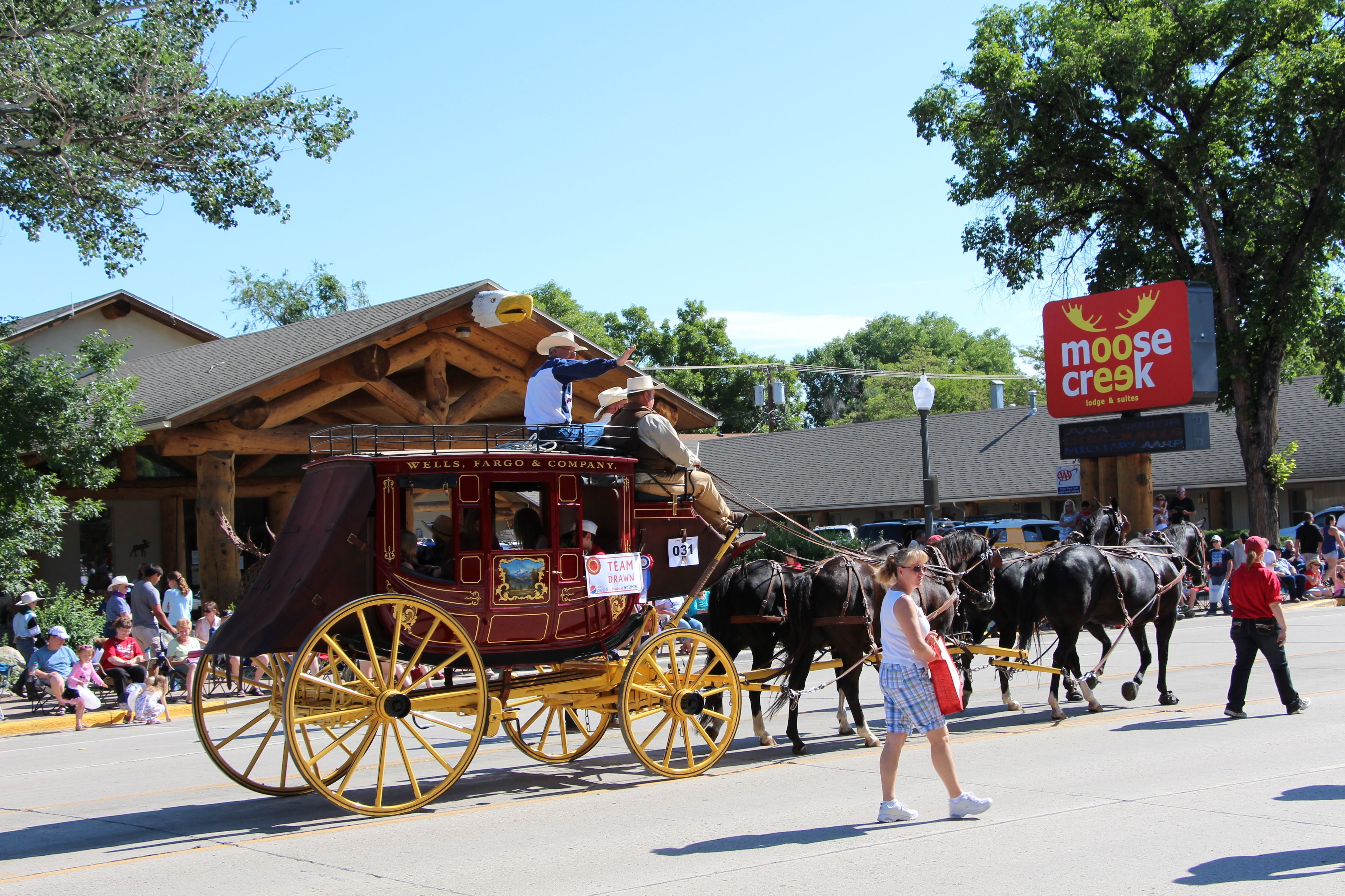 Une calèche tirée par des chevaux, portant une enseigne indiquant « Wells Fargo & Company » et une autre enseigne indiquant « Tirée par une équipe ».