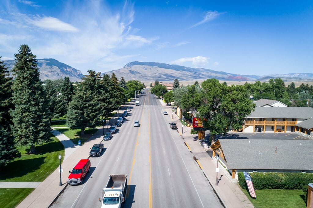 A street view with a building featuring a parking lot and a sign that reads "moo cres."