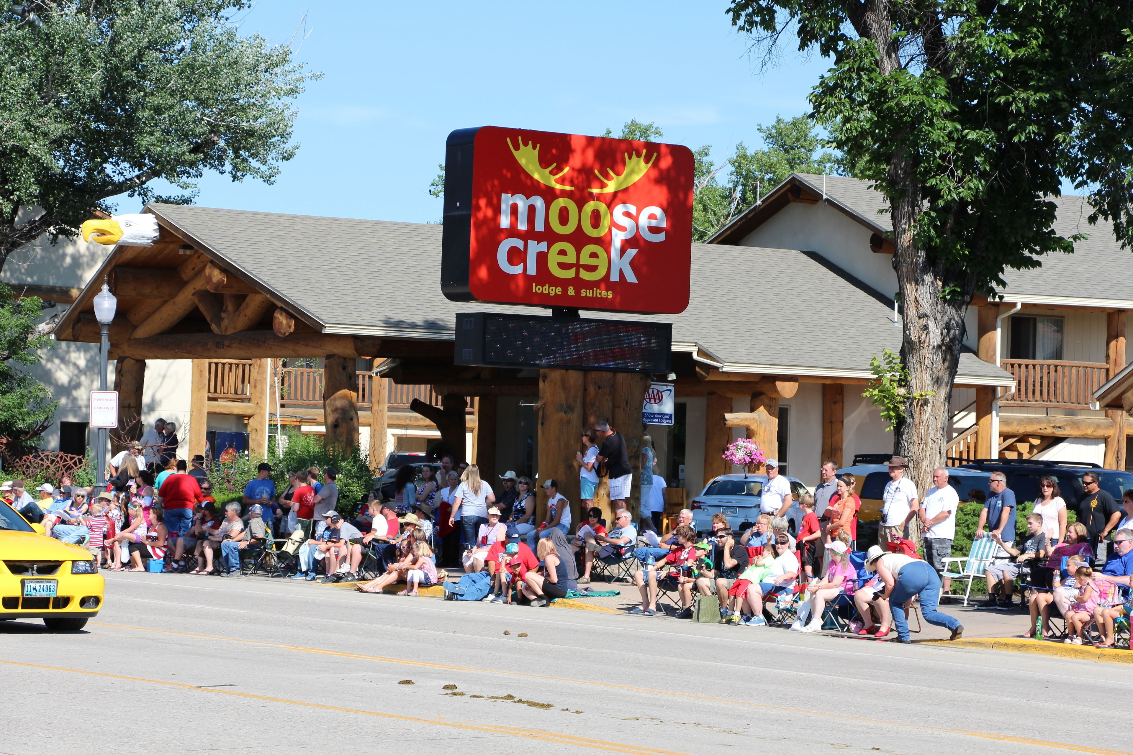 A building with a sign that reads "moose creek lodge & suites."