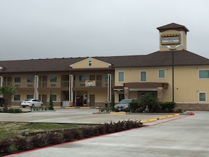 A two-story building with a sign indicating 'Downtown Inn' and 'Now Open.'