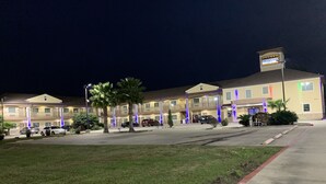 A hotel with multiple floors, a parking lot, and a sign indicating it is a DOWNTOWN INN.
