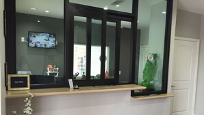 A reception desk with a 'NO PETS' sign, a small plant, and a security camera.
