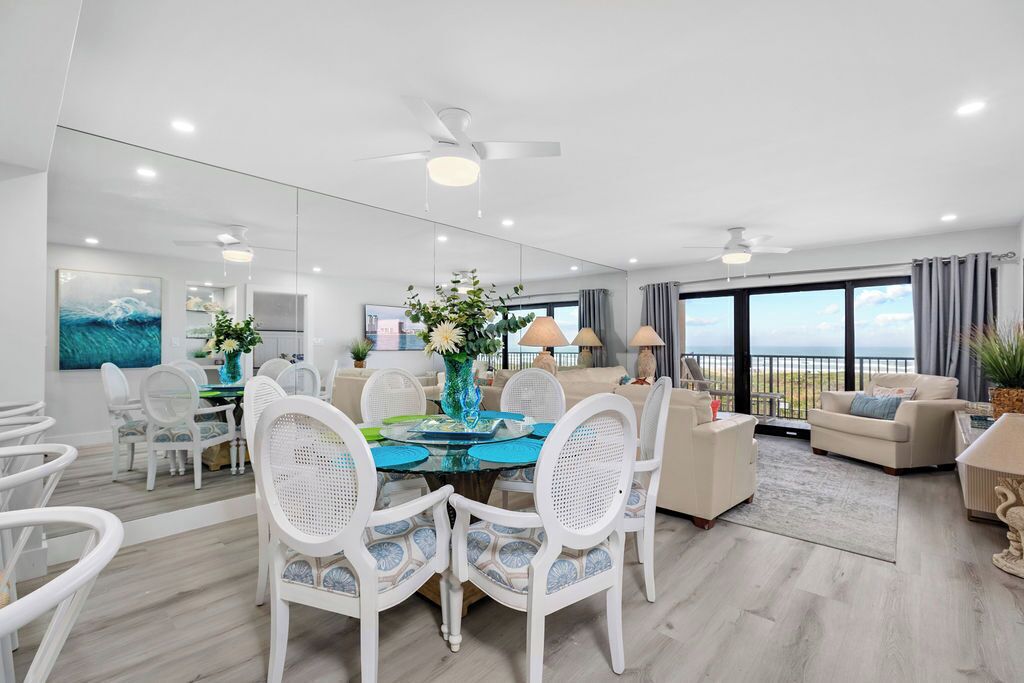 Un salon moderne avec un coin repas, de grandes fenêtres et un balcon offrant une vue dégagée.