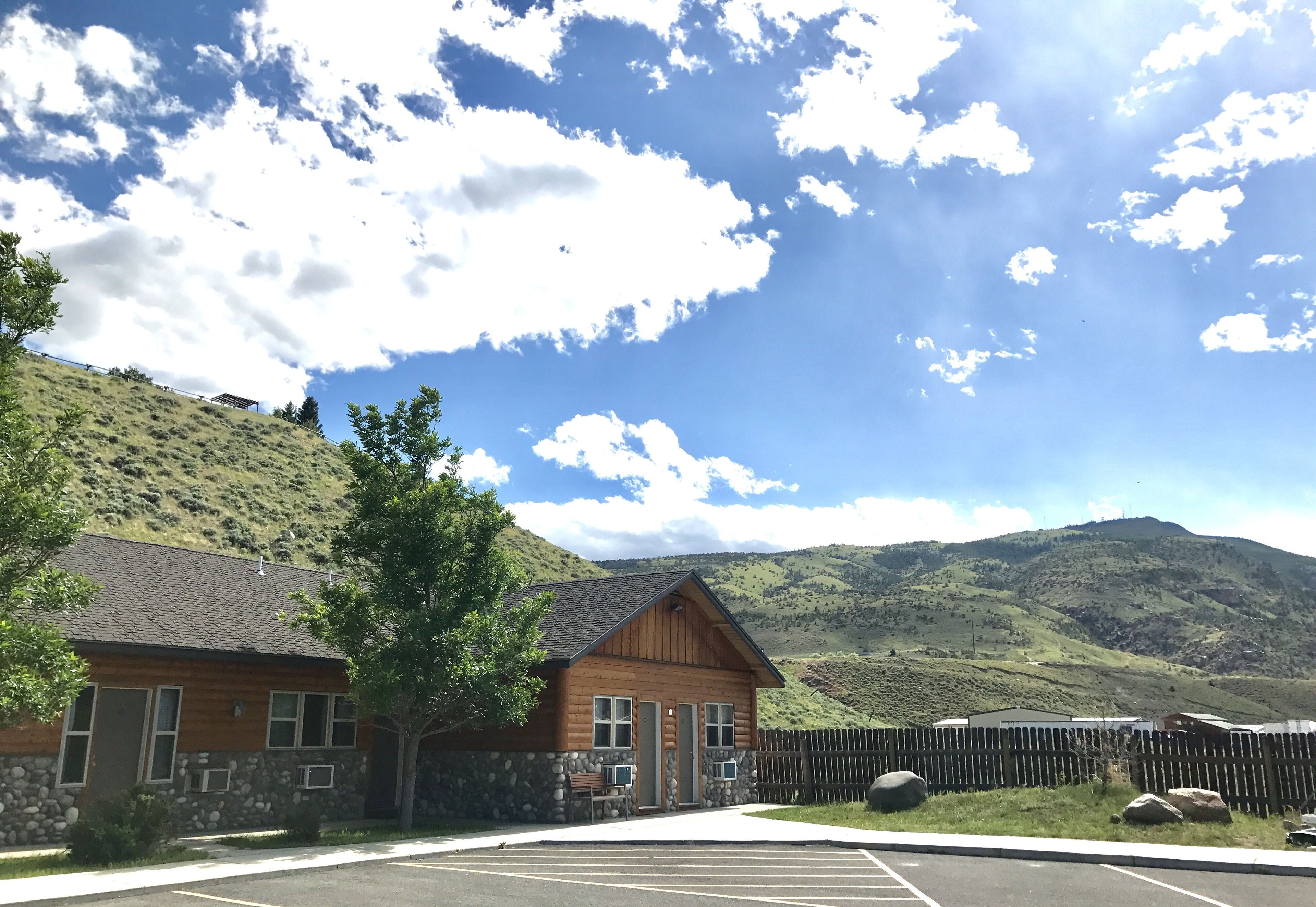 Un chalet doté d’une façade en pierre, d’un revêtement extérieur en bois et offrant une vue sur les montagnes.