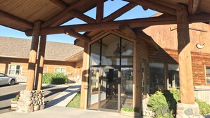 A wooden building with a covered entrance and large windows. - Cody Holiday Lodge (Cody)