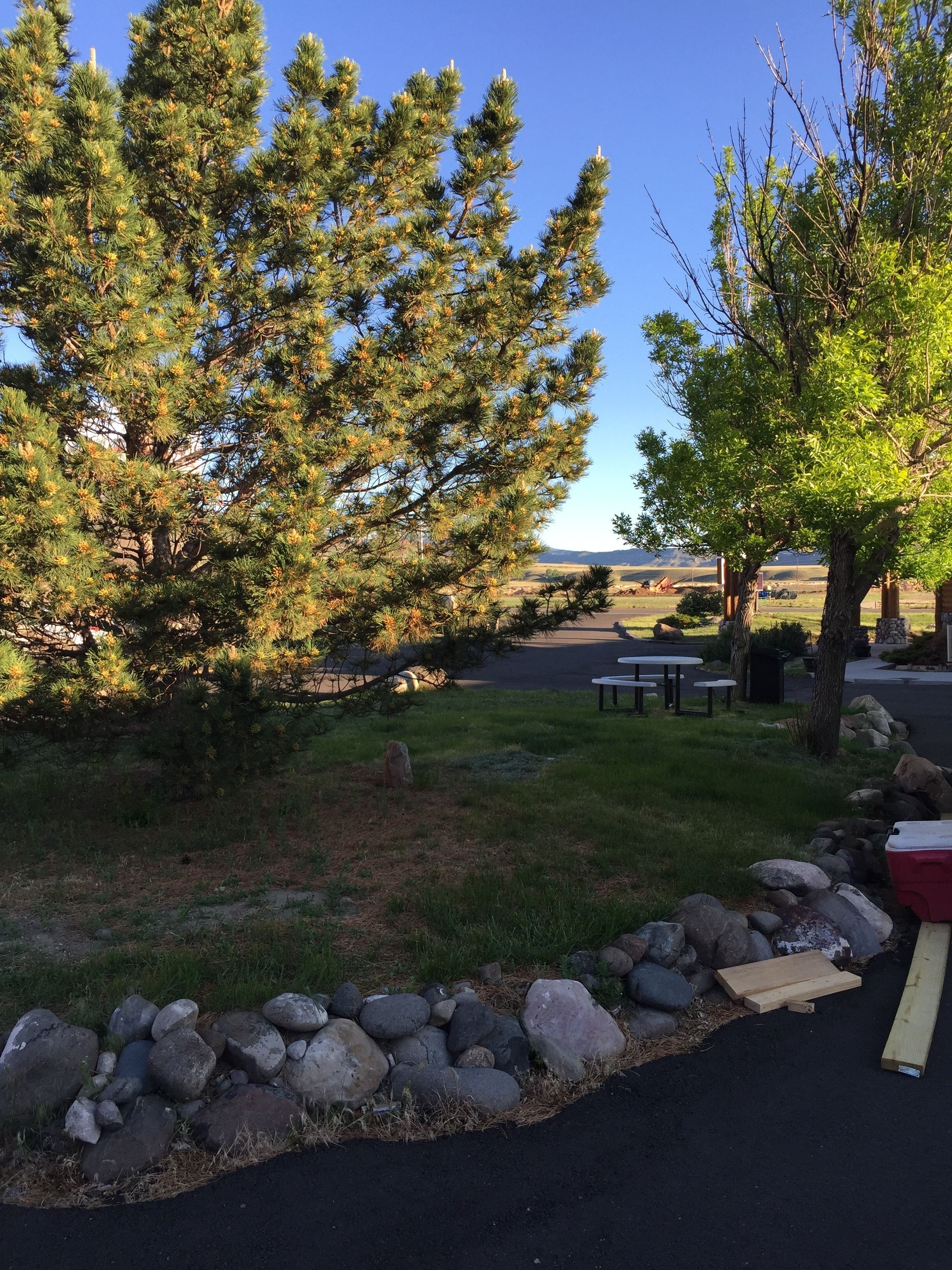 A parking area with picnic tables and a stone wall.