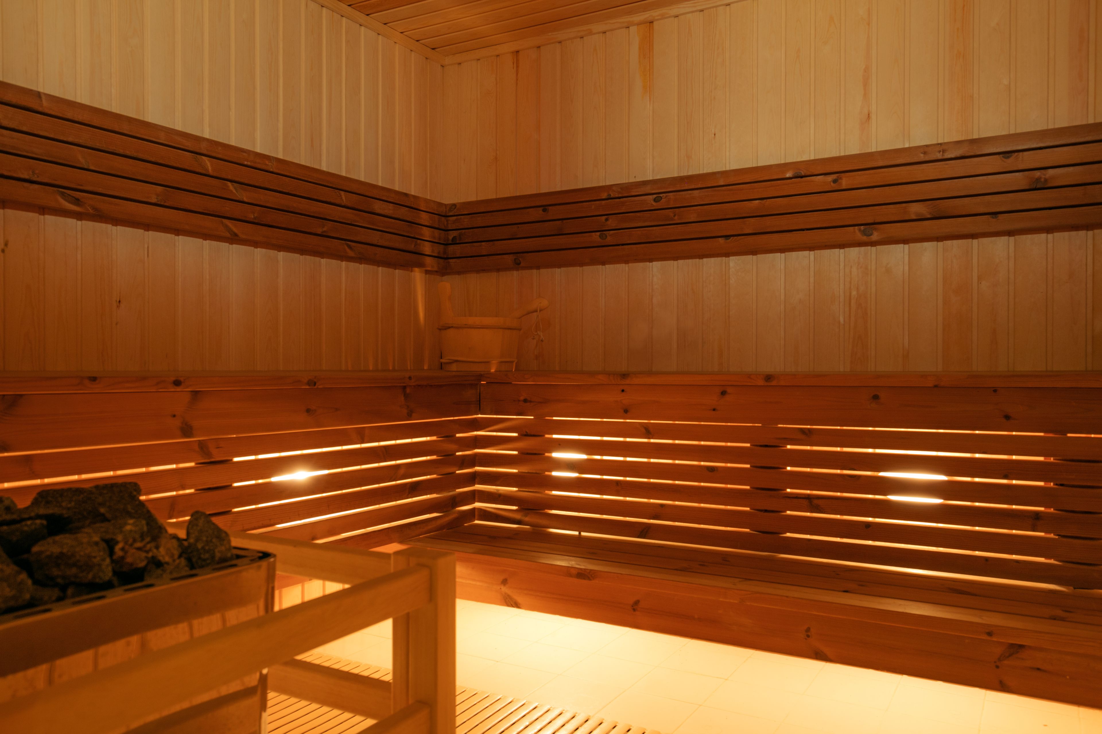 A sauna with wooden benches and a central heating element.