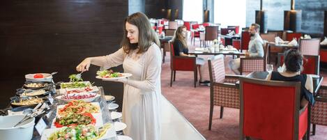 Un dispositiu de buffet a una zona de dinar amb diverses taules i caires.