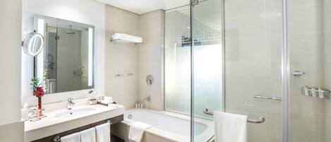 A modern bathroom with a glass-enclosed shower, a large mirror, and a vanity with a sink and towel rack.