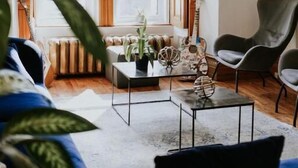 Una sala de estar acogedora con un ventanal grande, un sofá, una mesita de centro y un sillón.