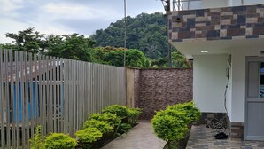 Un camino que lleva a un edificio con un muro de piedra y una entrada con azulejos.