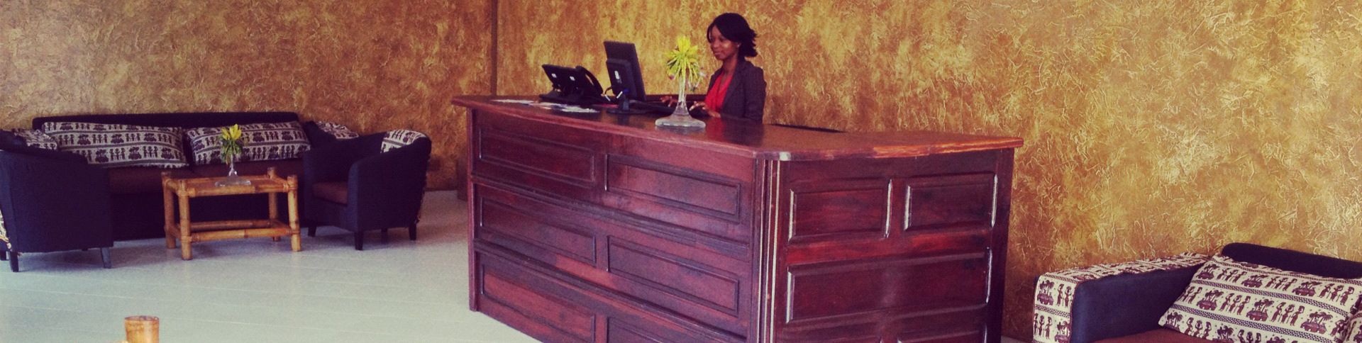 Un área de recepción con un escritorio de madera, un sofá y una silla.
