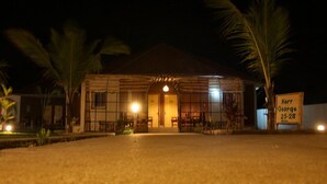 Un bâtiment doté d’une grande entrée ouverte, de palmiers et d’une enseigne.