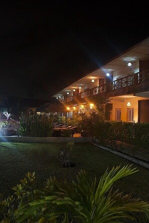 A two-story building with a balcony and outdoor lighting.