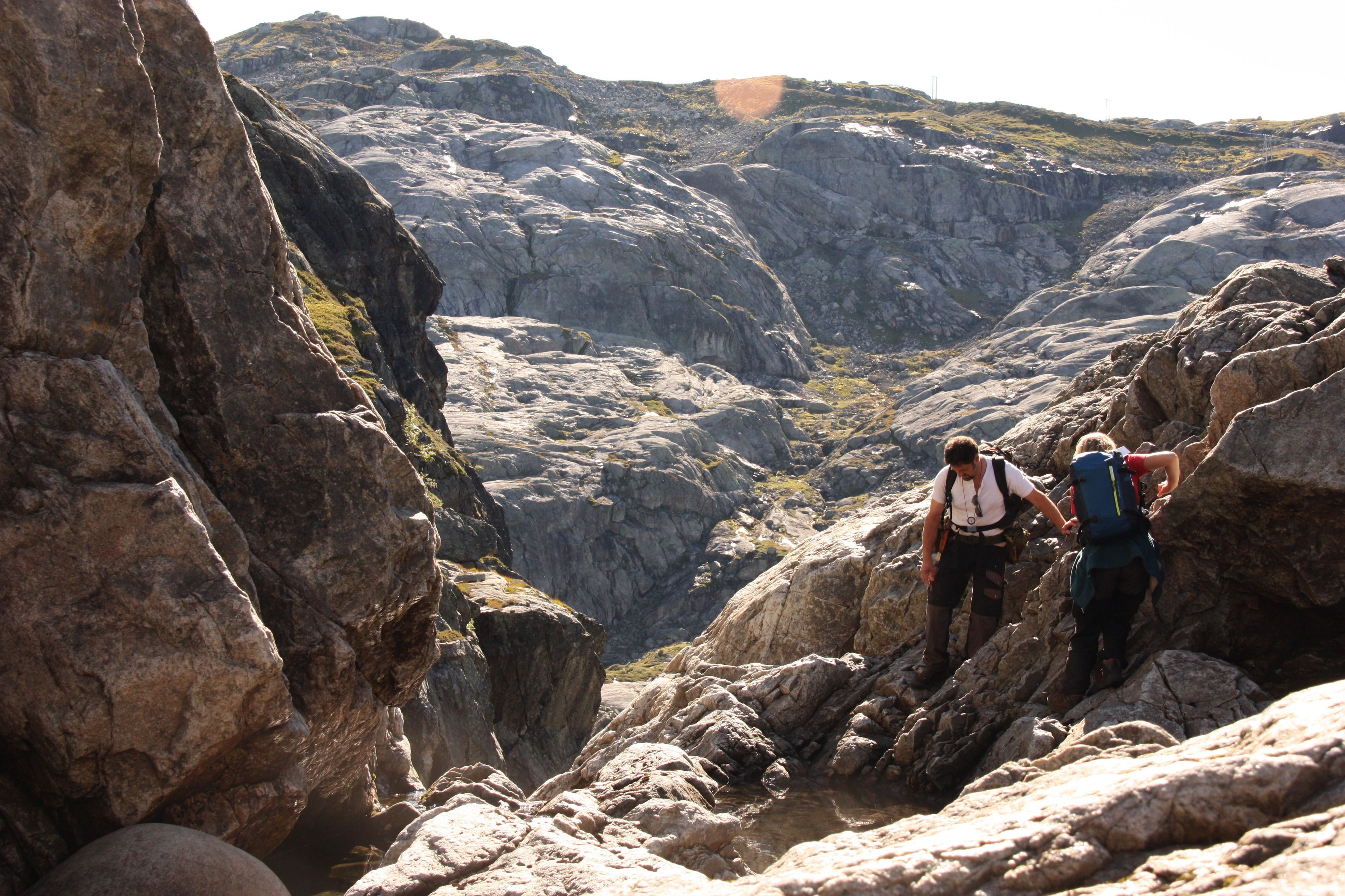 Un cañón rocoso con excursionistas recorriendo un sendero estrecho.