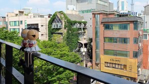 Vista de un paisaje urbano con edificios modernos, una combinación de estructuras residenciales y comerciales, y una barandilla de balcón.