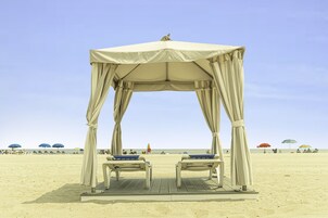 On the beach, white sand, beach cabanas, sun loungers