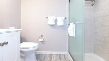 Un baño con inodoro, toallero y zona de ducha.