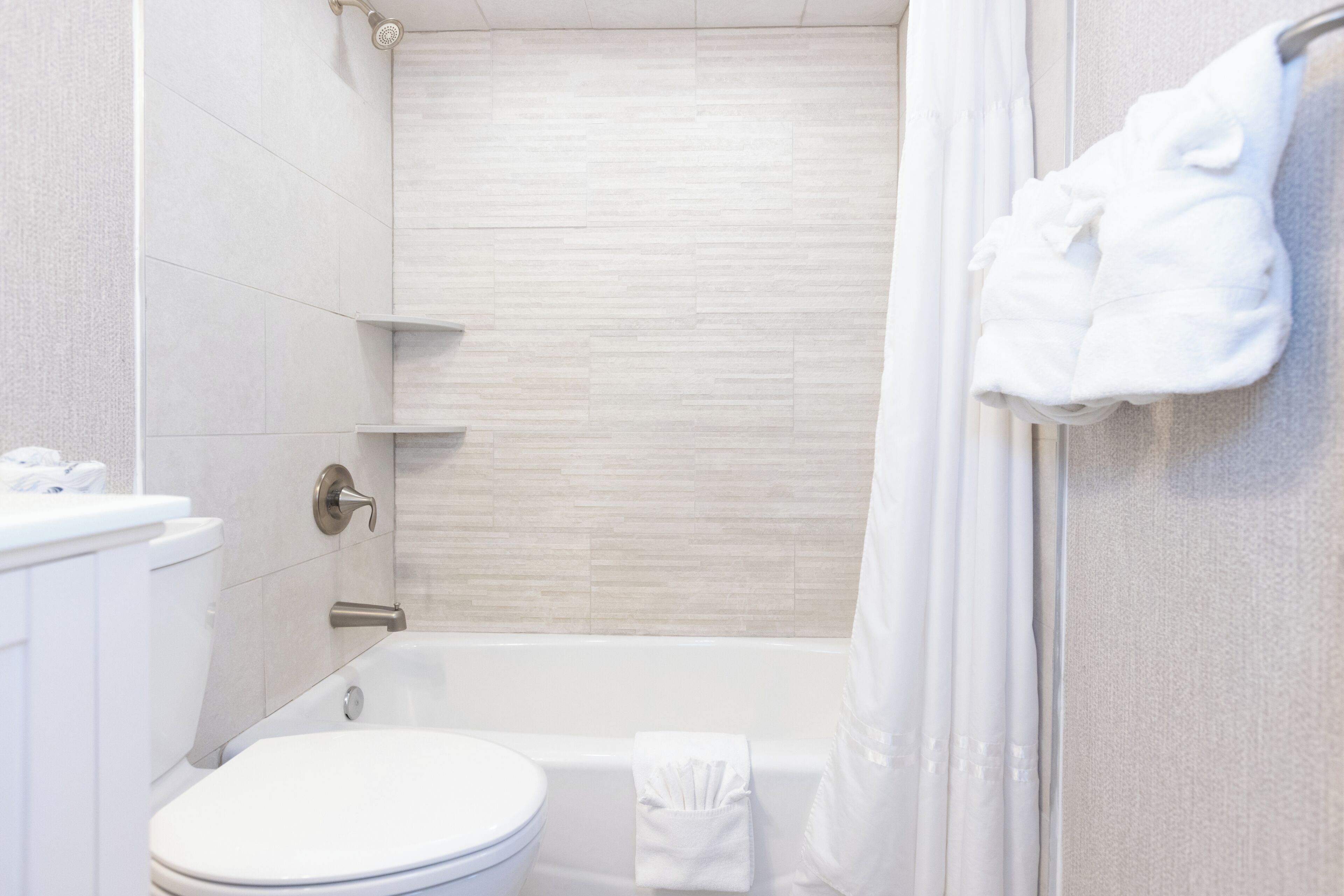 A bathroom with a toilet, bathtub, and shower curtain.