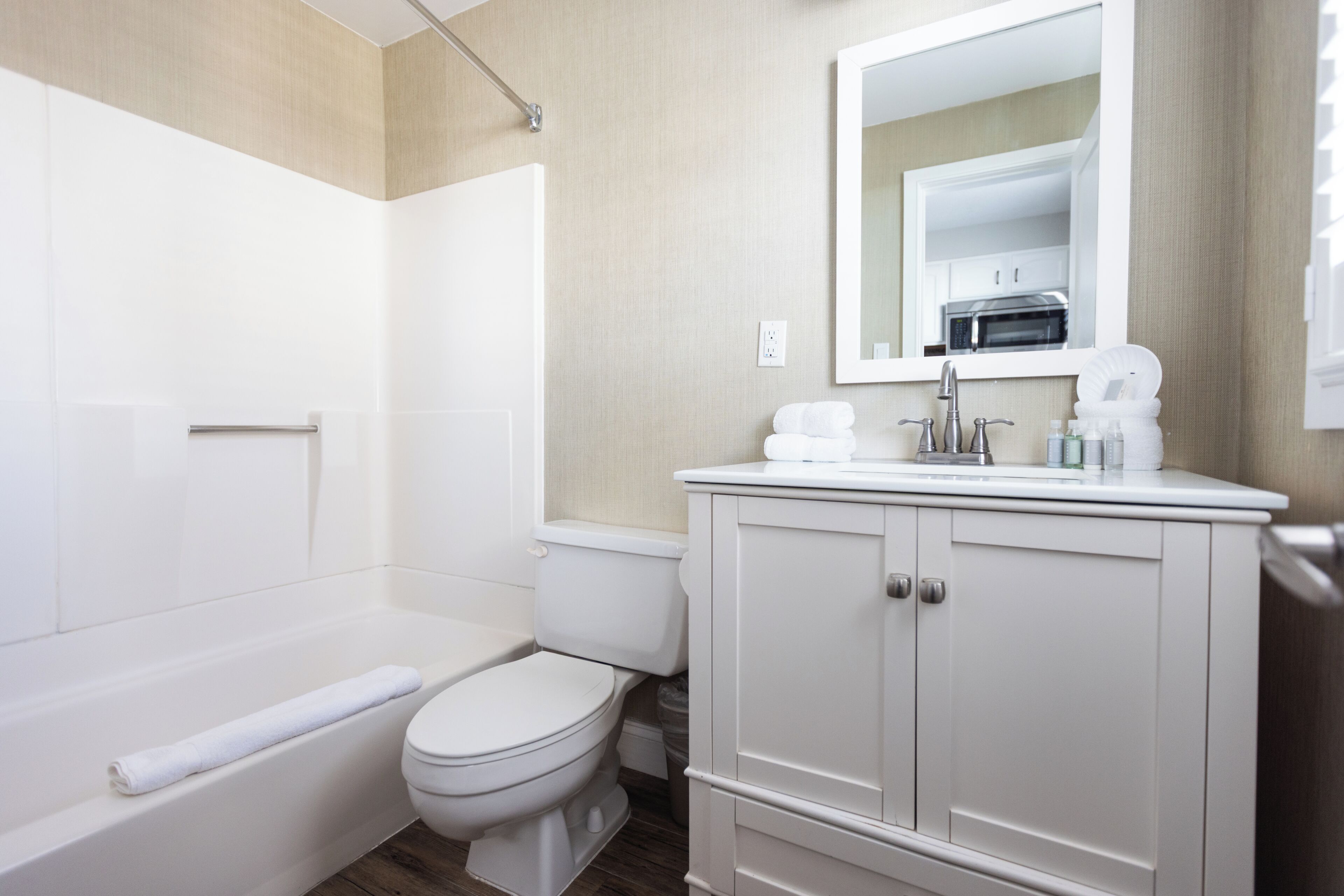 A modern bathroom with a bathtub, toilet, and vanity.