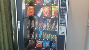 A vending machine stocked with various snacks and drinks. - Country Regency Inn & Suites (Manvel)