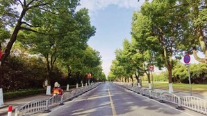 A tree-lined street with a clear road, barriers, and a no parking sign. - Zunyue Grace Hotel (Shanghai Lida University Branch) (Shanghai)