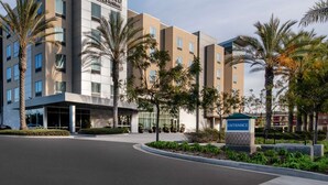 Un hotel moderno con un cartel que dice "Homewood Suites by Hilton" y una entrada despejada.