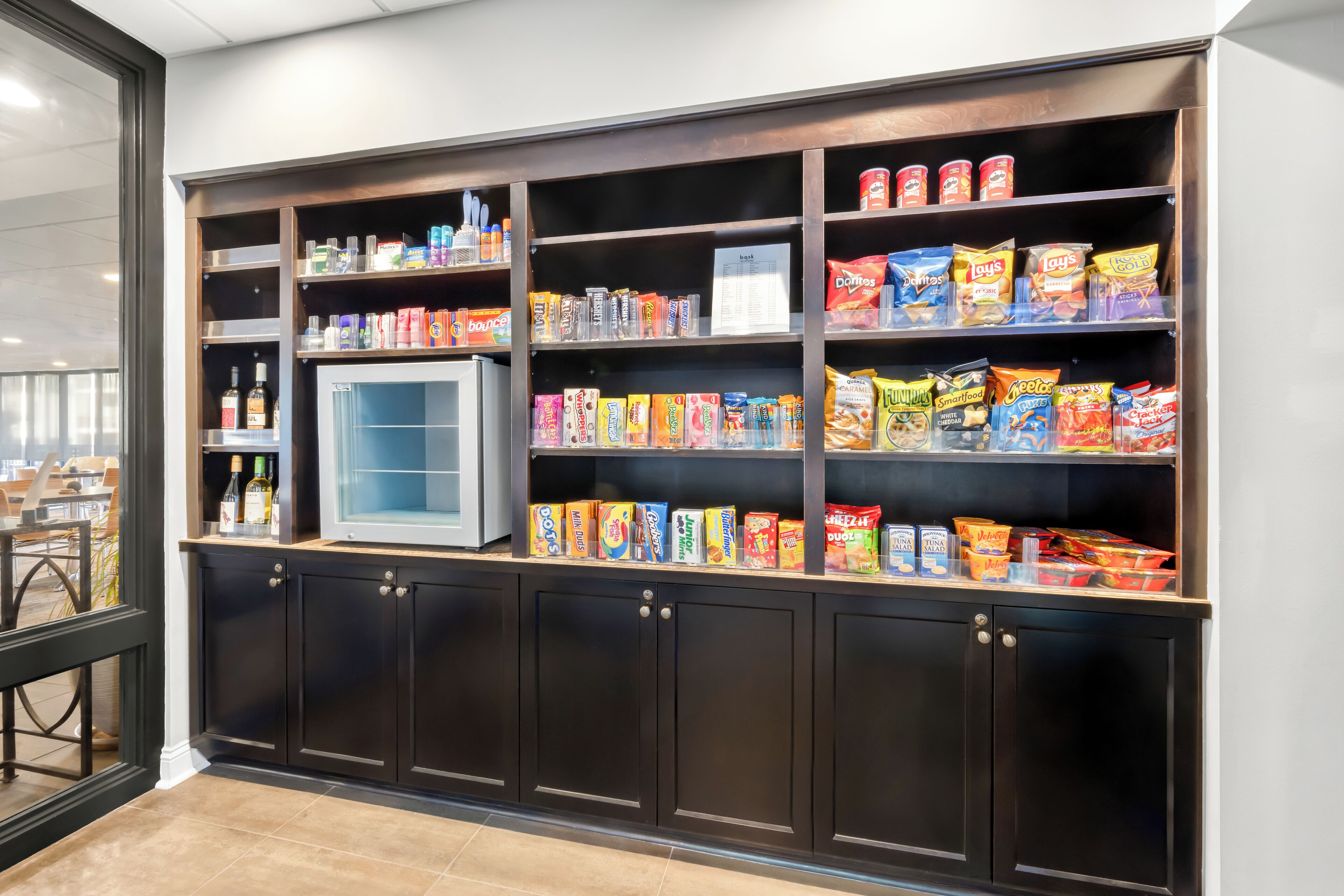Mostra de menjar petit amb diferents aliments envasellats i un frigorífic.